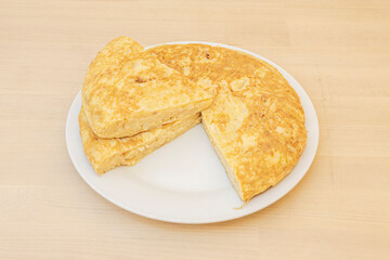Spanish omelette with potatoes and eggs with a separate portion and placed on top so that the interior is well set.