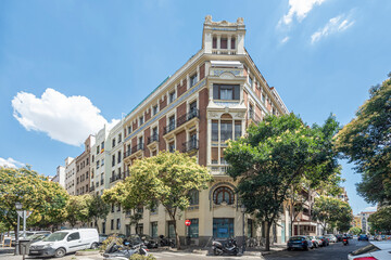 Fototapeta premium Architecture in the center of Madrid on a hot summer day. Representative buildings and parked vehicles.