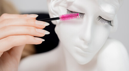 Concept woman eyelash extension practitioner uses brush for her daily care