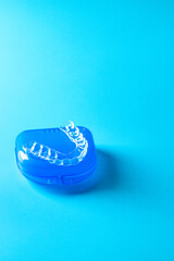 Invisible braces aligner on the blue container. Mobile orthodontic apparatus for the correction of teeth.