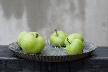 Natural green apples from the home garden on a gray background.