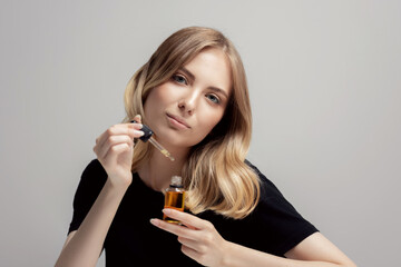 Fashion skin care with oil cosmetic for face body woman at home, grey background