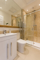 A stylish modern bathroom with built in shower cubicle, sink, and toilet