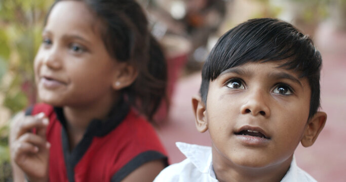 Two Indian Kids Looking Up Surprised And Smiling