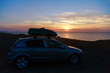 Plakat a trip to the sea by car. car on the beach sunset