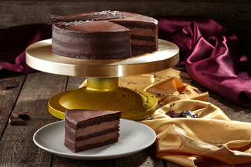 Sliced chocolate sponge cake with buttercream topped with ganache