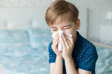 Caucasian boy suffers from a runny nose and allergic reactions to pollen. Colds viral diseases in...