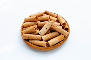 Thai crispy coconut rolls with sesame in bamboo basket on white