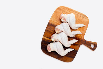 Fresh raw chicken wings on wooden cutting board on white