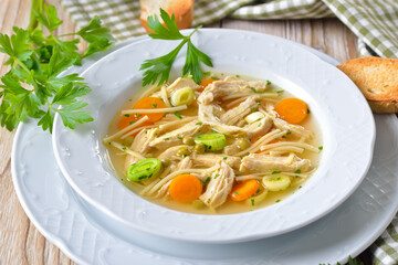 Delicious homemade chicken soup with peaces of chicken breast and fresh vegetables in season - obrazy, fototapety, plakaty