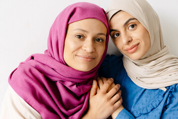 Two smiling women wearing hijab standing together