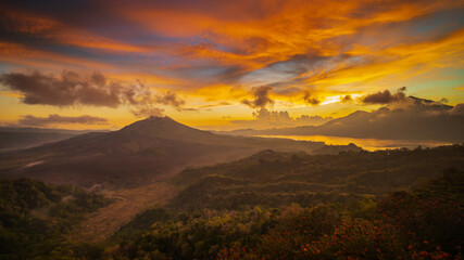 Plakat Beautiful mountain landscape during sunrise. Hills, Batur volcano and lake. Scenic panoramic view. Colorful sky with clouds. Foggy morning. Kintamani, Bali