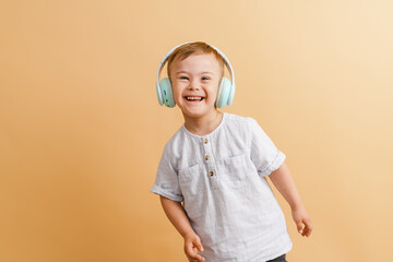 White boy with down syndrome in headphones smiling at camera