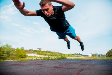 Man performs clapping push-ups on sportsground