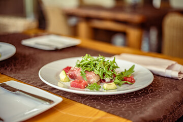 Salad of red fish Salmon, roll with Kamchatsky crab, arugula, avocado, sesame and oil