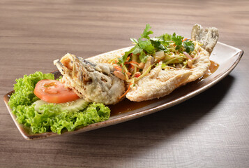 deep fried crispy whole grouper fish with mango salad dressing on wood background asian halal menu