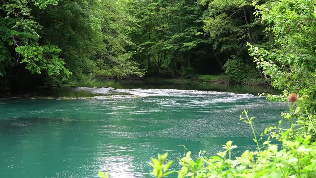 The threshold is located on a small mountain river, water flows between the stones. Blue water After the glacier melt. Croatia
