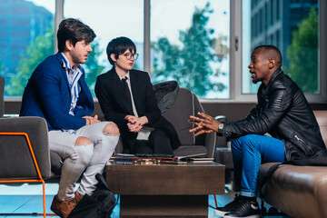 Three multi-ethnic businesspeople having a meeting in a modern office.