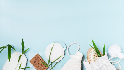Spa and bath concept, massage brush, white towel with spa accessors on light blue background.   
