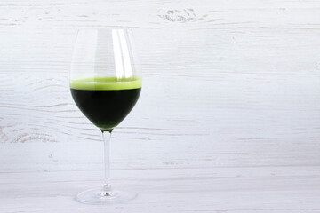 Detox wheatgrass juice in a glass shot and wheat grains on a wooden background. wellness shots. healthy shot. Nutrition food. green superfood drink