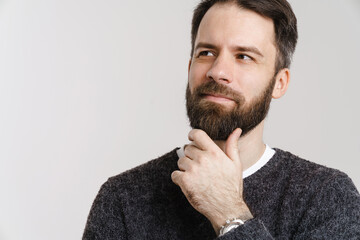 White puzzled man with beard posing and looking aside