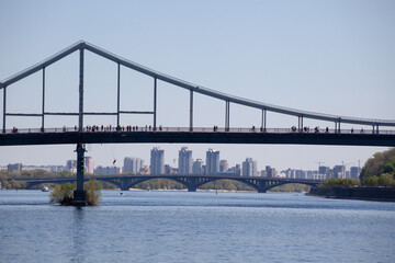 Parkovy Pedestrian Bridge about Dnieper river with ships passing beneath, Kiev, Ukraine....