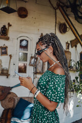 Woman in green dress using her phone inside room