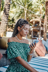 Woman in dress with mobile phone in bali hotel