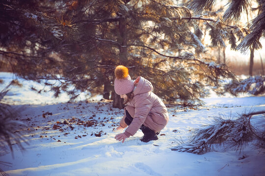 Little girl having fun on sunny beautiful winter day