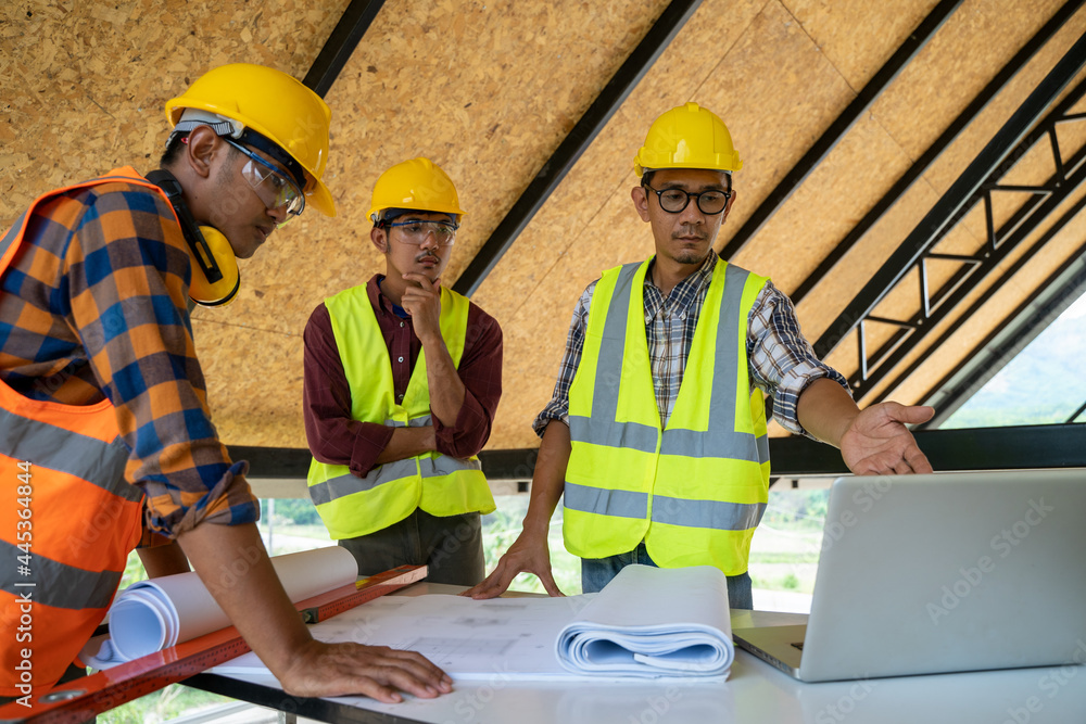 Poster engineers or architect holding a pen with drawings in construction on blueprints in construction sit