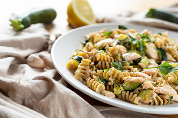 Fusilli pasta with zucchini and salmon fish.