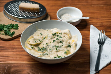 Ravioli with mushrooms, Parmigiano, parsley and fresh basil. Wooden table setup. Close up