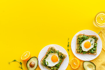 Fototapeta na wymiar Eggs and avocado with spinach on toasted bread. Top view