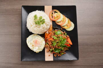 stir fried minced chicken meat in spicy chilli  sauce with white rice and fried egg on wood background asian halal set lunch menu