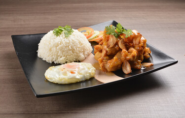 stir fried chicken meat in garlic soy sauce with white rice and fried egg on wood background asian halal set lunch menu