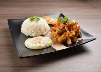 stir fried chicken meat in garlic soy sauce with white rice and fried egg on wood background asian halal set lunch menu