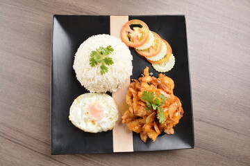 stir fried chicken meat in garlic soy sauce with white rice and fried egg on wood background asian halal set lunch menu