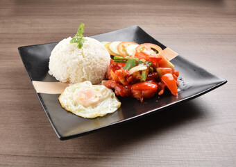 stir fried chicken meat in sweet and sour sauce with white rice and fried egg on wood background asian halal set lunch menu