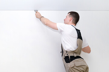 worker installs a stretch ceiling.