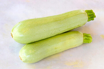 Green zucchini on a white wooden background