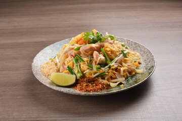 wok fried noodle phad Thai with chicken meat on wood background asian halal set lunch menu
