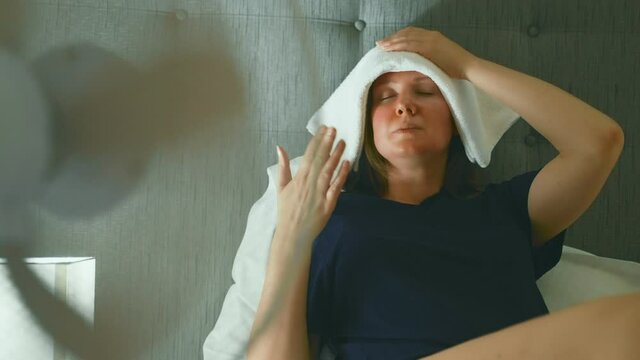 Woman tries to cool off during the intense heat in front of cooling fan.