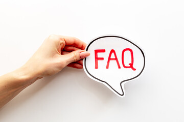 Hands with faq word on paper bubble. Frequently asked questions concept
