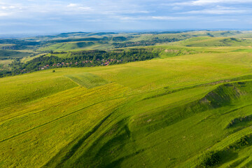 Fototapeta na wymiar Aerial view of countryside vibrant green hills. Transylvania, Romania