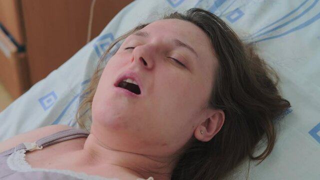 Labor pains of a pregnant woman on a bed in a maternity ward hospital