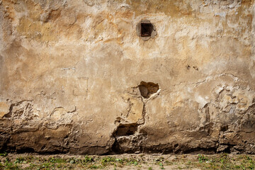Old yellow plaster and brick wall