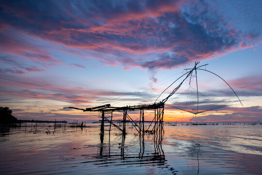 silhouette scenery of sunrise at pakpra phatthalung with thai traditional fishing trap