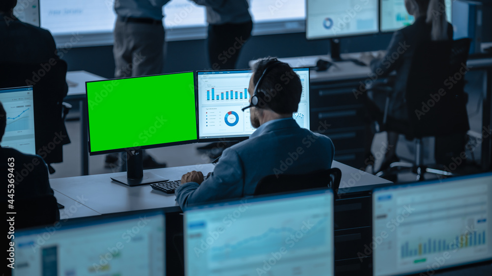 Poster Green Screen Horizontal Mock Up on a Computer Display Used by a Male Trade Specialist. Team of  Brokers and Finance Specialists  Sit in Front of Computers and Work with Big Data.