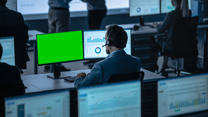 Green Screen Horizontal Mock Up on a Computer Display Used by a Male Trade Specialist. Team of ...