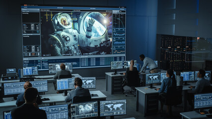 Group of People in Mission Control Center Establish Successful Video Connection on a Big Screen...